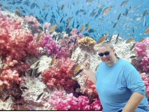 Kerry McLean teaches in front of a large tv screen featuring pink corals