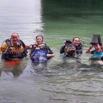 Divers holding mesh bags full of trash